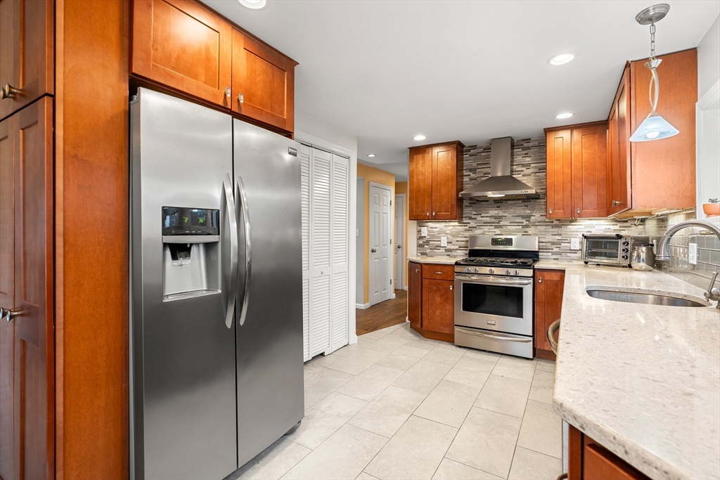 51 Winslow Road Reading, MA 01867 - Photo 10 of 40 a kitchen with stainless steel appliances granite countertop a stove a refrigerator and a sink