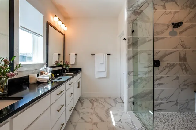 a bathroom with double vanity and a mirror