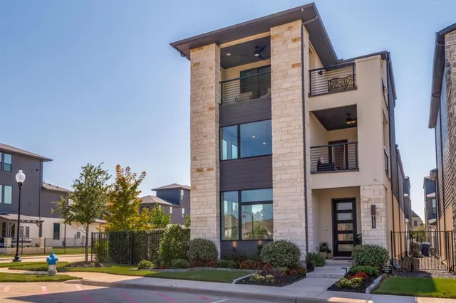 a front view of a multi story residential apartment building with yard and parking space