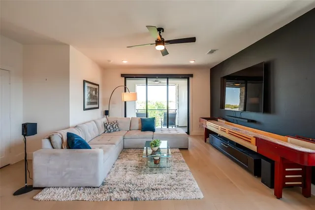 a living room with furniture kitchen view and a large window