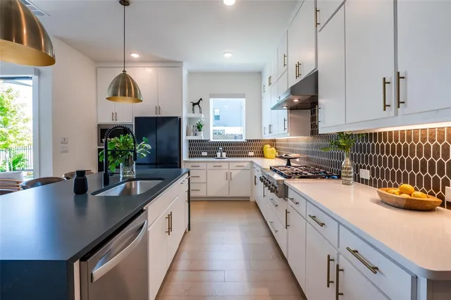a kitchen with counter top space a sink stainless steel appliances and cabinets