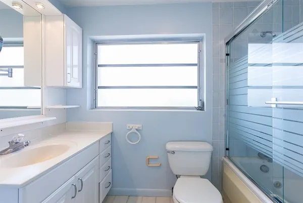 a bathroom with a sink a toilet and window