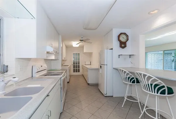 a kitchen with cabinets and chairs