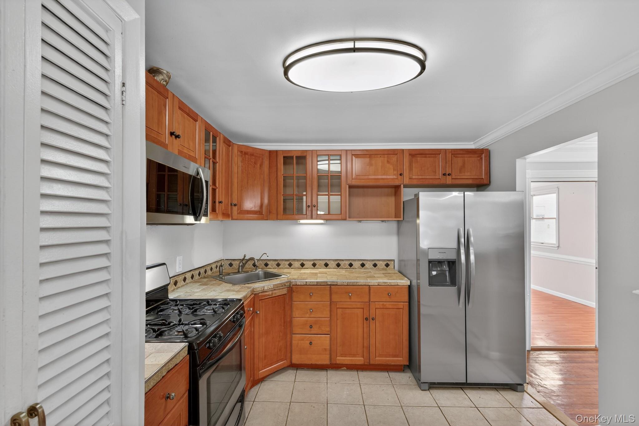 138 Spring Street Massapequa, NY 11758 - Photo 10 of 45 a kitchen with stainless steel appliances granite countertop a stove a sink and a refrigerator