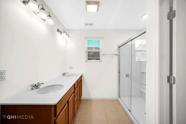 a bathroom with a sink and mirror with shower