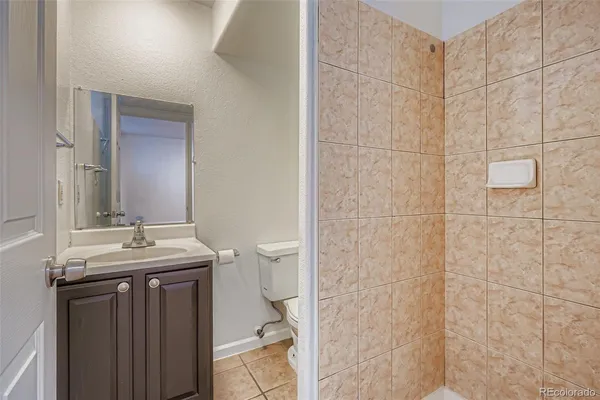 a bathroom with a granite countertop sink a toilet and a mirror