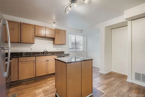 a kitchen with stainless steel appliances granite countertop a stove a sink and a refrigerator