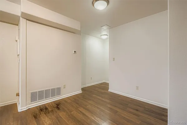 a view of an empty room with wooden floor