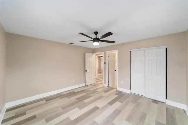a view of a livingroom with a ceiling fan & wooden floor