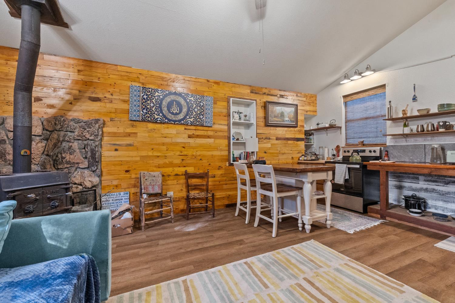 1480 Pennsylvania Gulch Road Murphys, CA 95247 - Photo 28 of 31 a dinning room with stainless steel appliances kitchen island granite countertop a stove a refrigerator a dining table and chairs with wooden floor