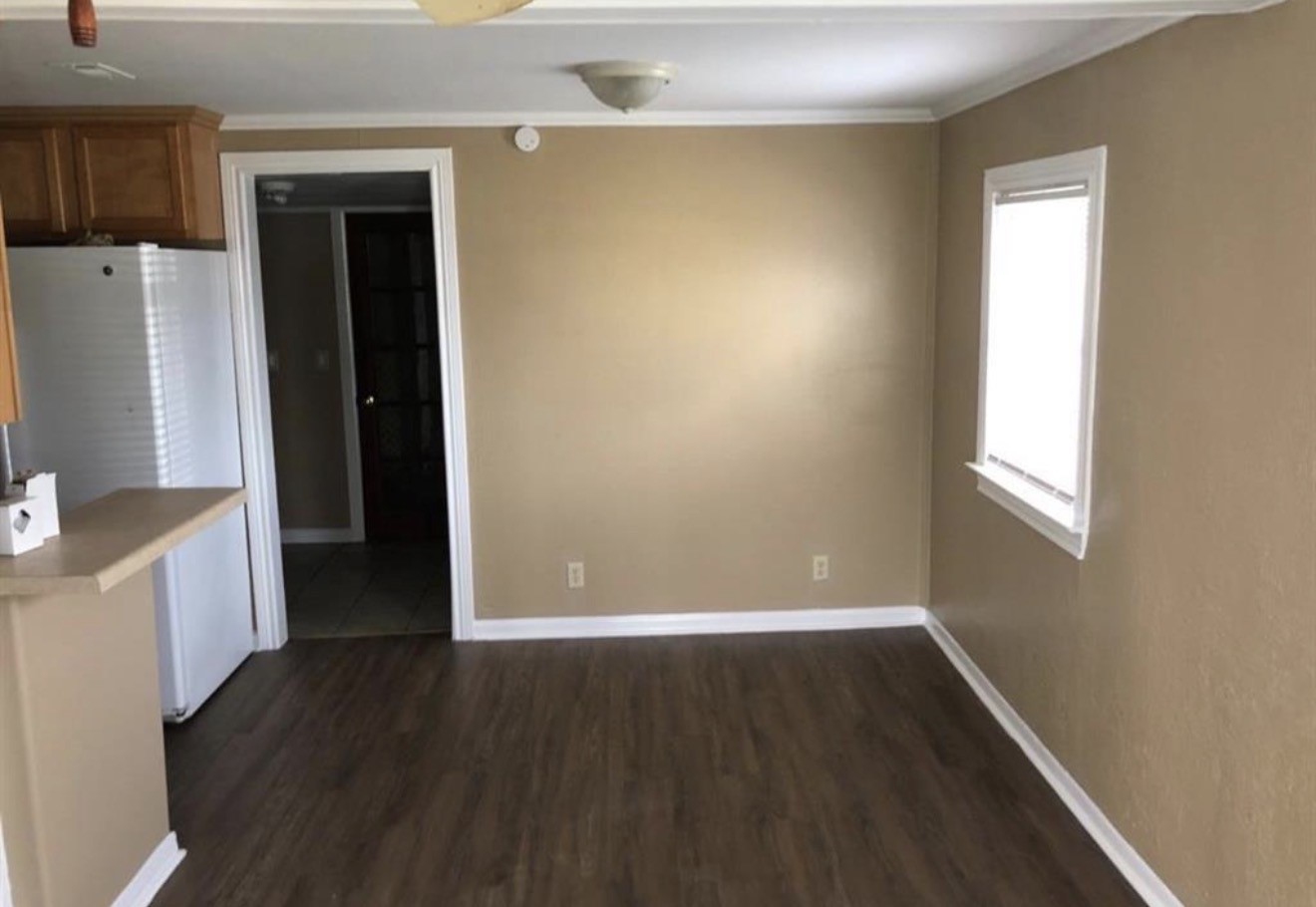 2308 10th Avenue La Marque, TX 77568 - Photo 7 of 8 an empty room with wooden floor and a window