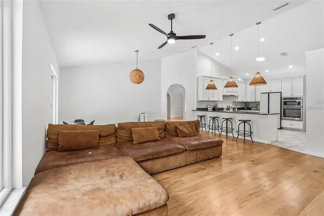 a living room with furniture kitchen view and a chandelier