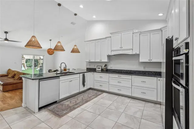 a kitchen with stainless steel appliances granite countertop a sink and cabinets