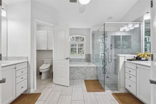 a bathroom with a granite countertop sink a toilet a mirror and shower