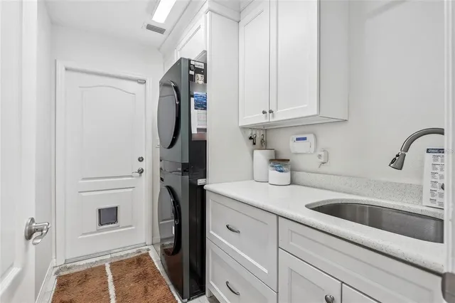 a kitchen with white cabinets and refrigerator