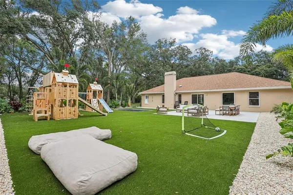 a front view of a house with garden and trees