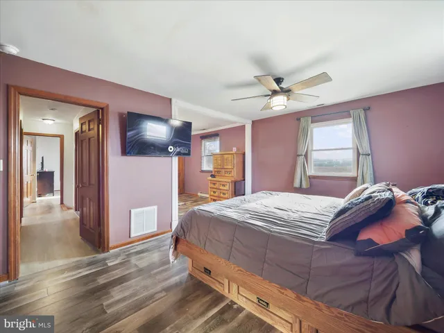 a spacious bedroom with a large bed a chandelier and closet