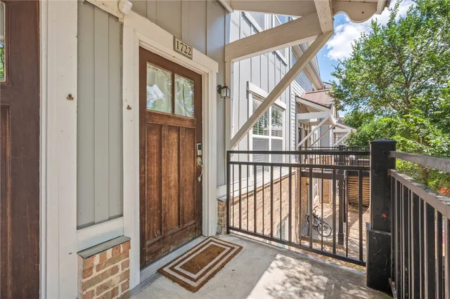 a front view of a house with a yard and potted plants