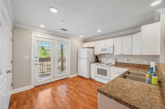 a kitchen with white cabinets and appliances