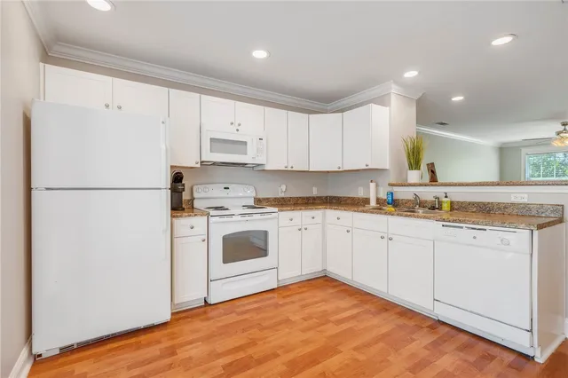 a kitchen with granite countertop white cabinets and white appliances