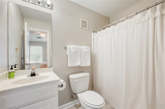 a bathroom with a sink a toilet and shower curtain