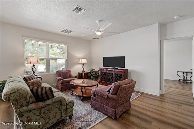 a living room with furniture ceiling fan and a window