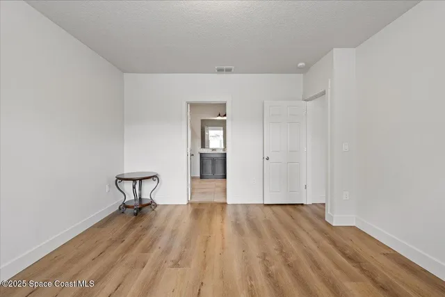 a view of a room with wooden floor and a bench