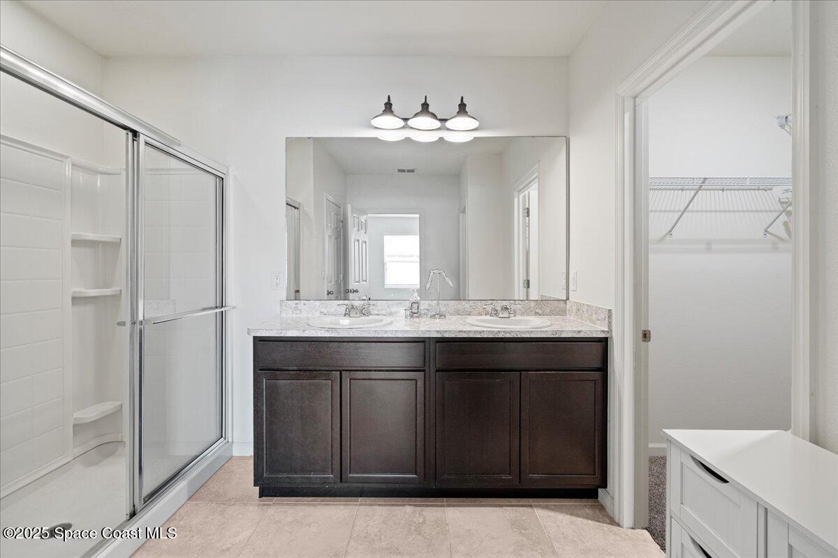 1120 Swiss Pointe Lane Rockledge, FL 32955 - Photo 16 of 47 a bathroom with a granite countertop sink a mirror and a shower