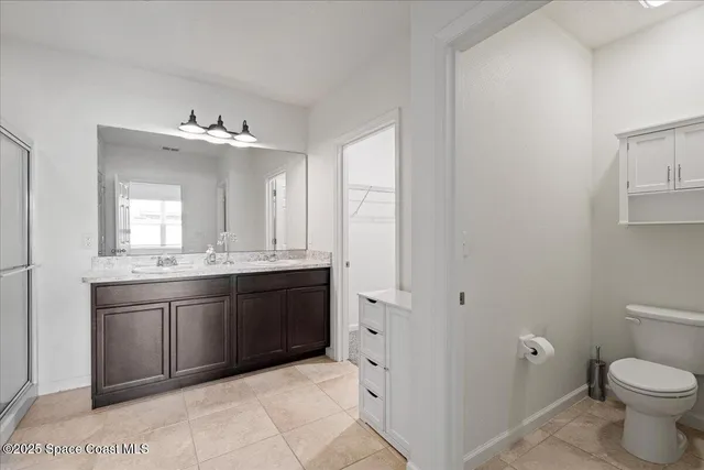 a spacious bathroom with a granite countertop sink a toilet and a mirror