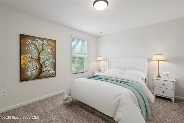 a bedroom with a bed and a painting on the wall