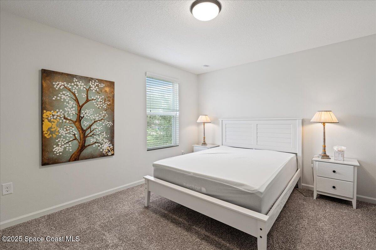 1120 Swiss Pointe Lane Rockledge, FL 32955 - Photo 21 of 47 a large bed sitting in a bedroom next to a window and a chandelier