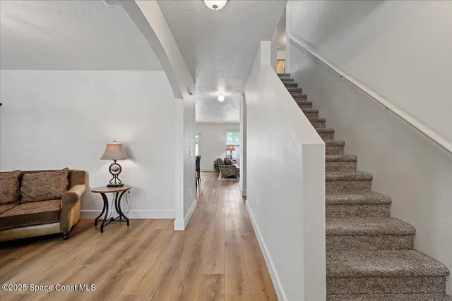 a view of entryway and hall with wooden floor
