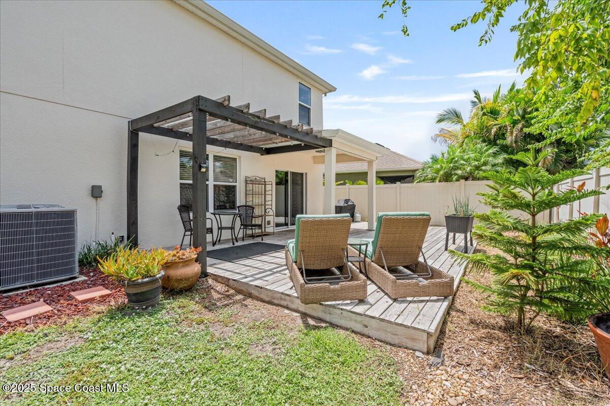 1120 Swiss Pointe Lane Rockledge, FL 32955 - Photo 39 of 47 a view of a patio with table and chairs potted plants and a large tree