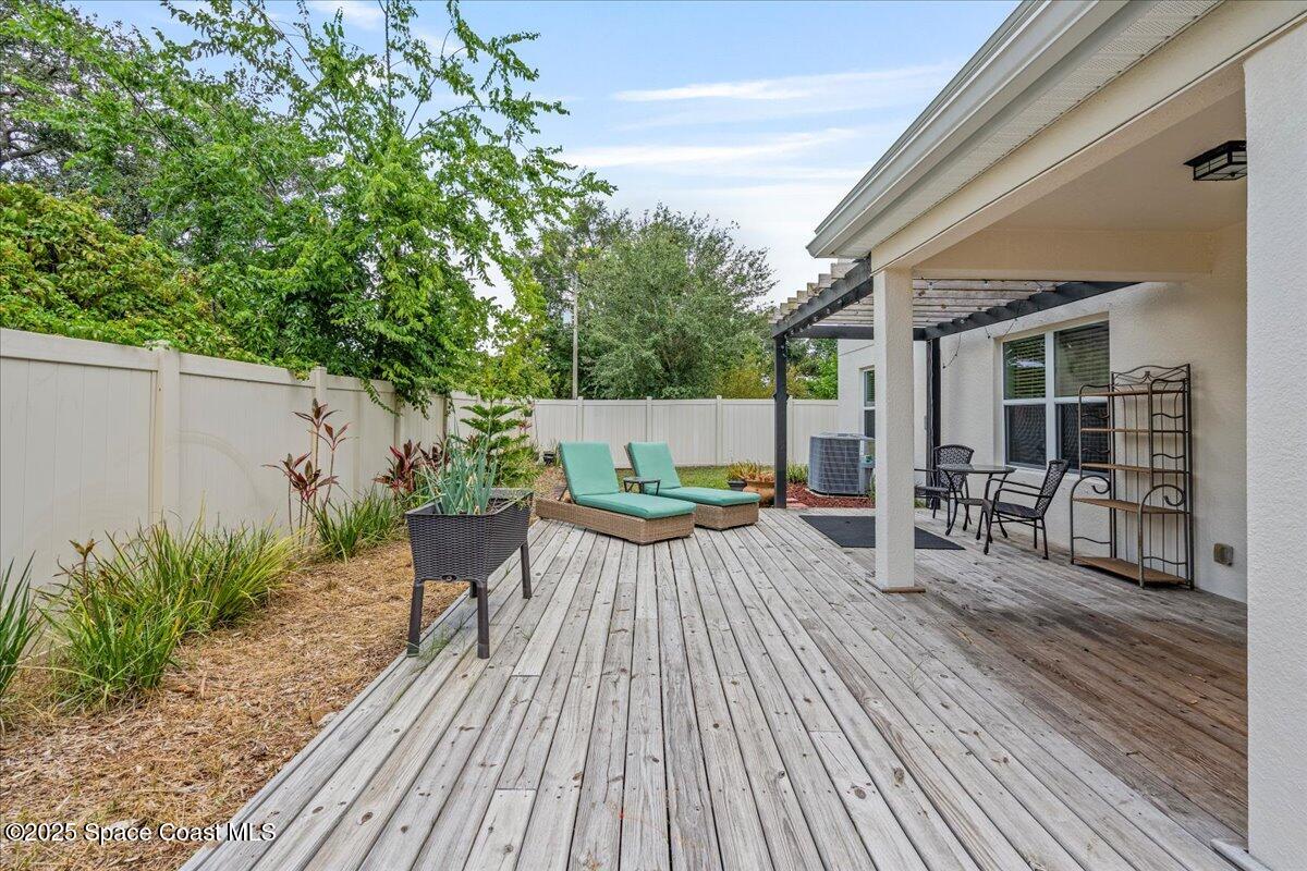 1120 Swiss Pointe Lane Rockledge, FL 32955 - Photo 43 of 47 a view of a patio with table and chairs potted plants with wooden floor and fence