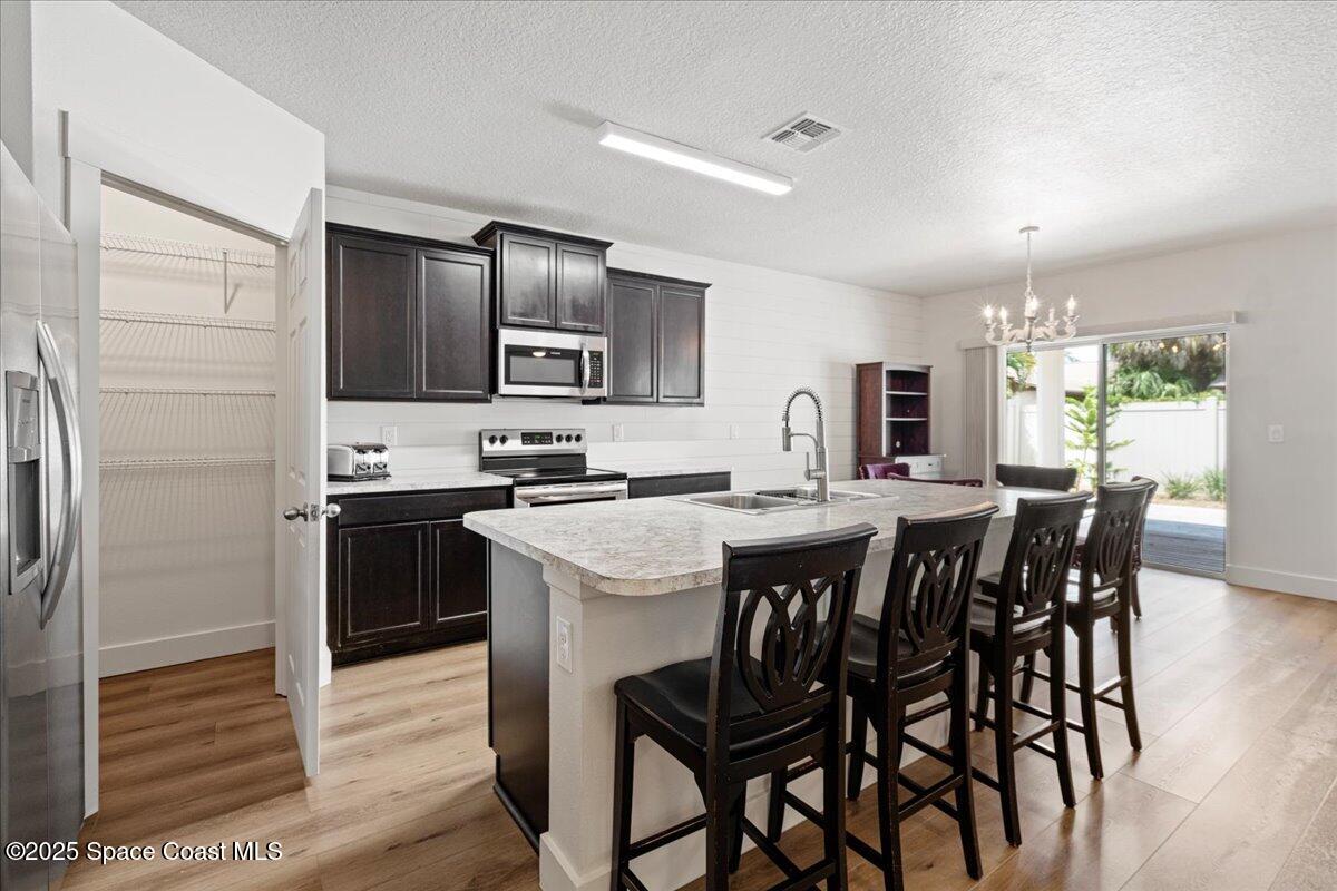 1120 Swiss Pointe Lane Rockledge, FL 32955 - Photo 6 of 47 a large kitchen with kitchen island a dining table and chairs