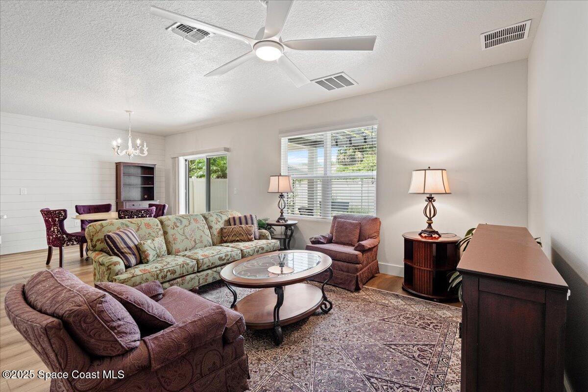 1120 Swiss Pointe Lane Rockledge, FL 32955 - Photo 9 of 47 a living room with furniture a lamp and a chandelier