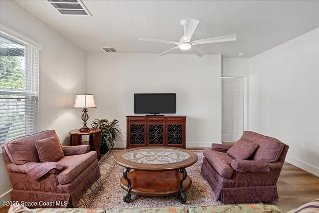 a living room with furniture a flat screen tv and a window