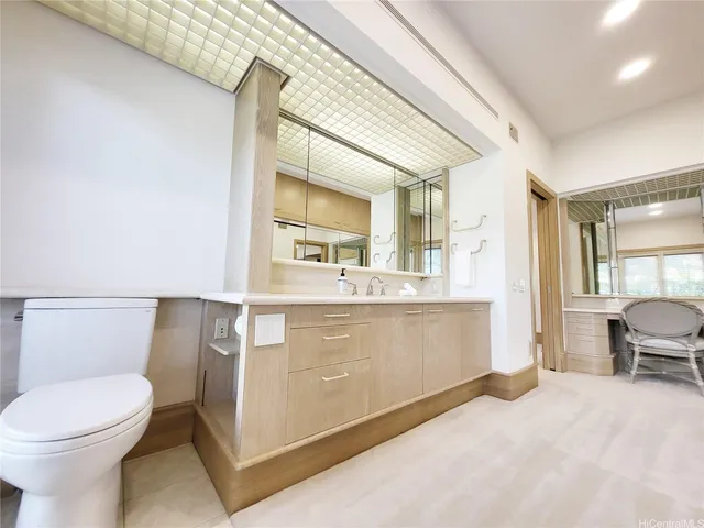a bathroom with a sink mirror vanity and toilet