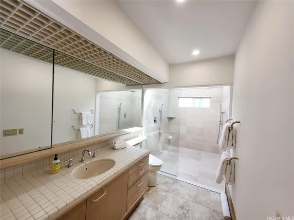 a bathroom with a granite countertop sink mirror and bathtub