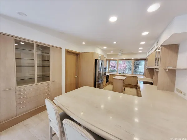 a kitchen with stainless steel appliances a large counter top a refrigerator and a sink