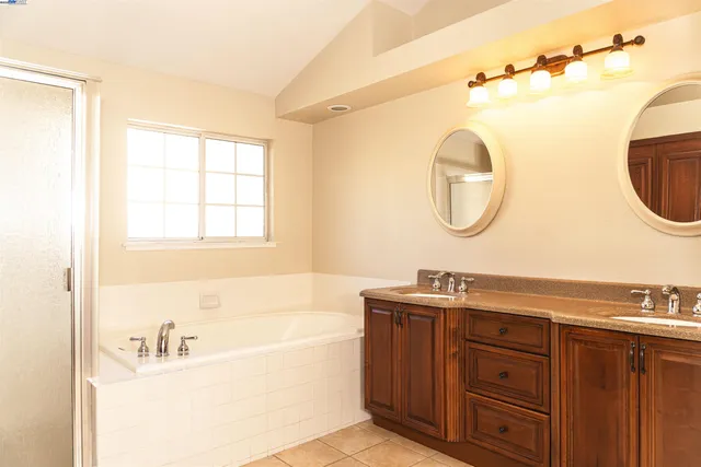 a bathroom with a tub sink and mirror