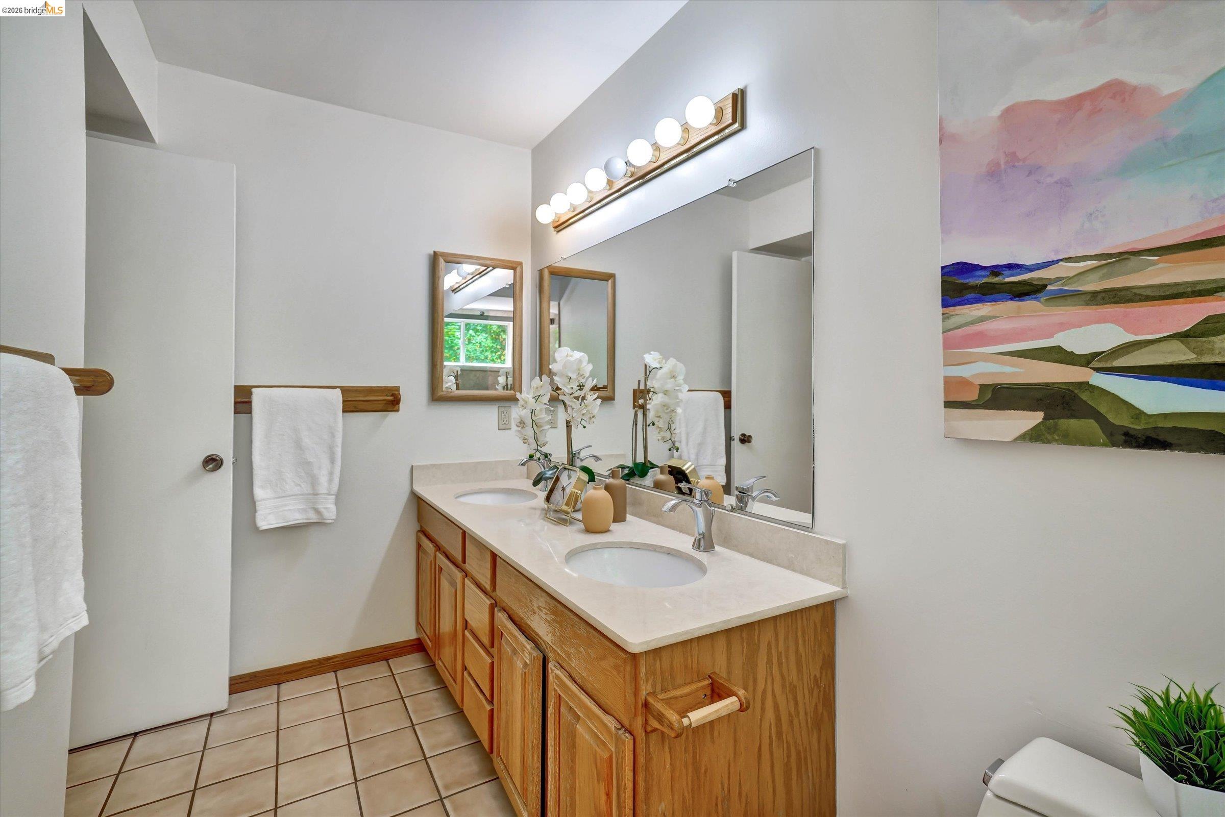 2826 Wright Avenue Pinole, CA 94564 - Photo 32 of 70 Bathroom featuring a double vanity with light wood cabinetry, a light-colored countertop, and two integrated sinks