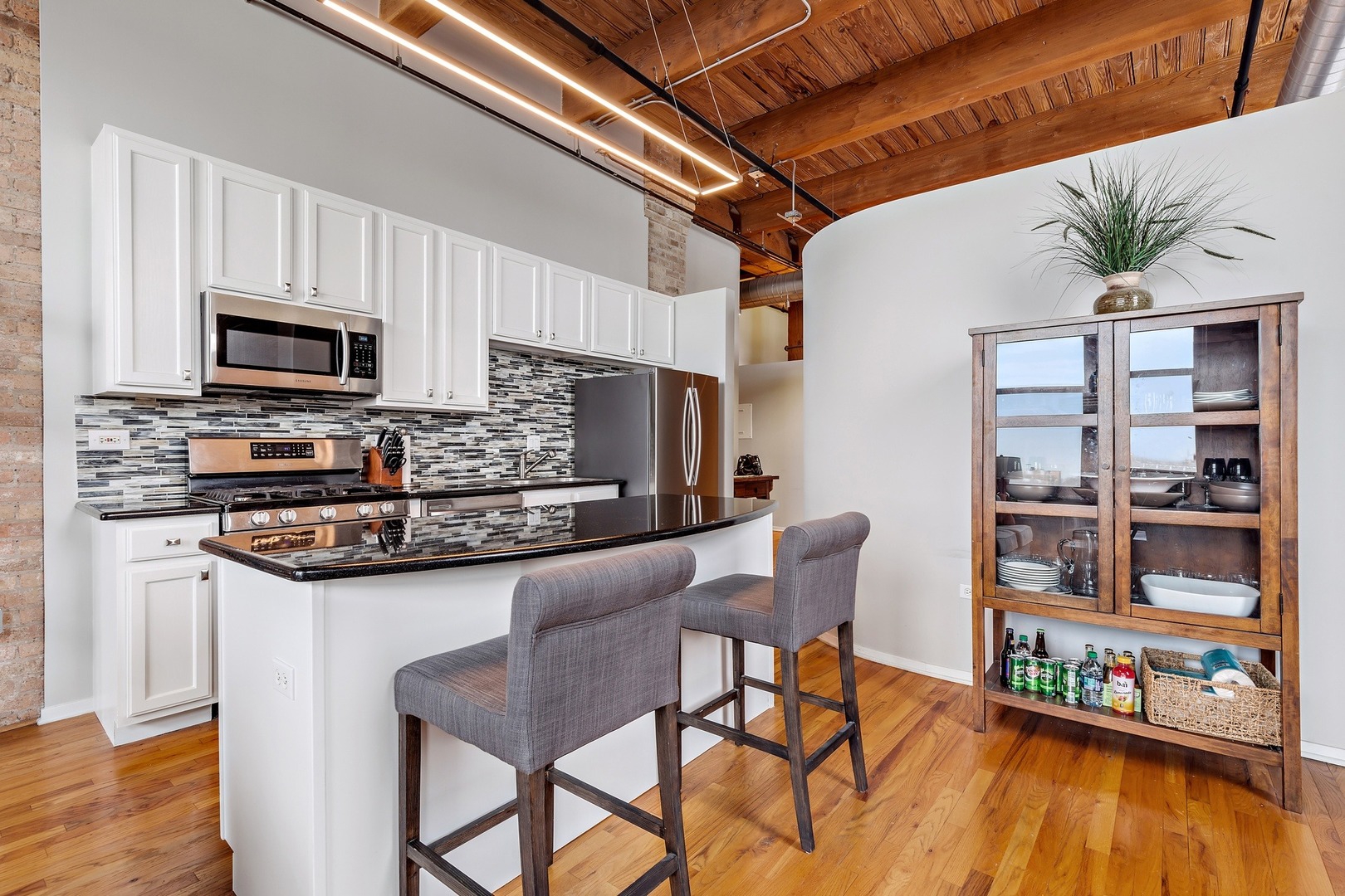 1500 West Monroe Street, Unit 401 Chicago, IL 60607 - Photo 11 of 24 a kitchen with stainless steel appliances granite countertop a table chairs microwave and sink