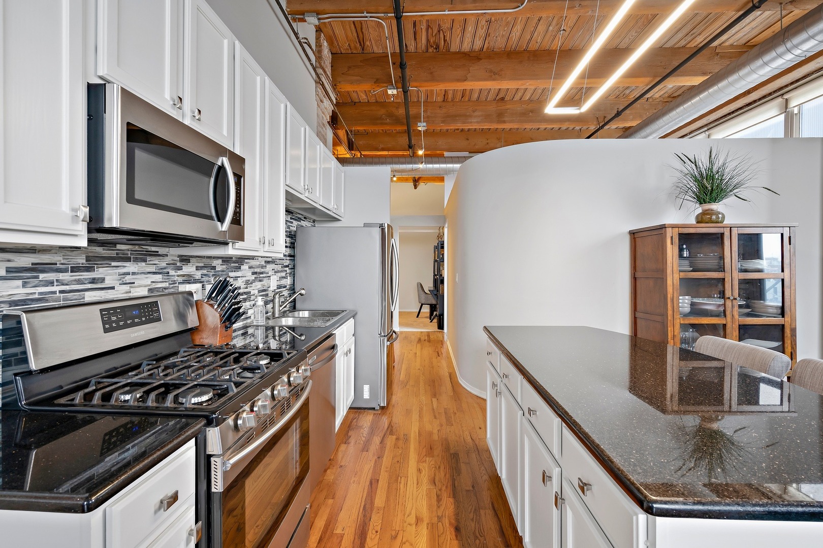 1500 West Monroe Street, Unit 401 Chicago, IL 60607 - Photo 9 of 24 a kitchen with stainless steel appliances granite countertop a stove and a microwave
