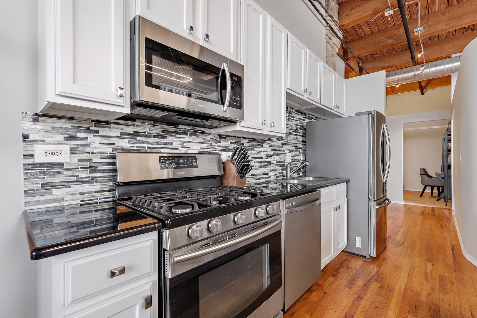 1500 West Monroe Street, Unit 401 Chicago, IL 60607 - Photo 10 of 24 a kitchen with stainless steel appliances granite countertop a stove and a microwave