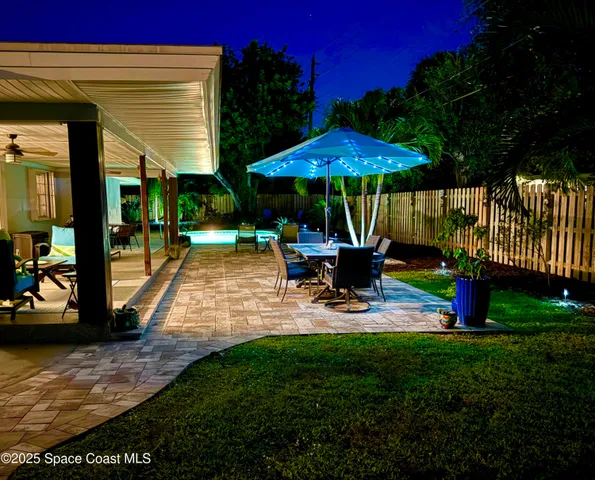 a view of a patio with table and chairs a barbeque with wooden fence