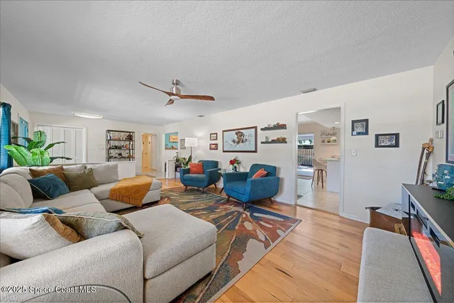 a living room with furniture kitchen view and a window