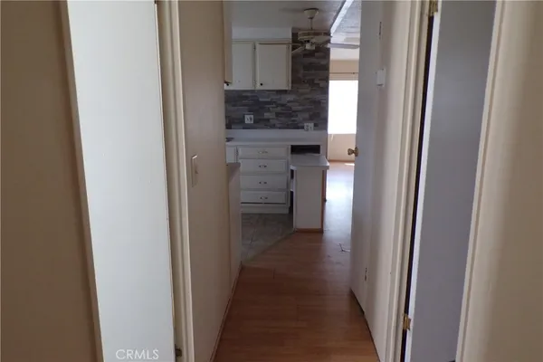 a view of a hallway with wooden floor