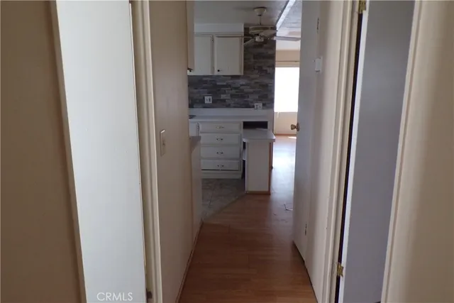 a view of a hallway with wooden floor
