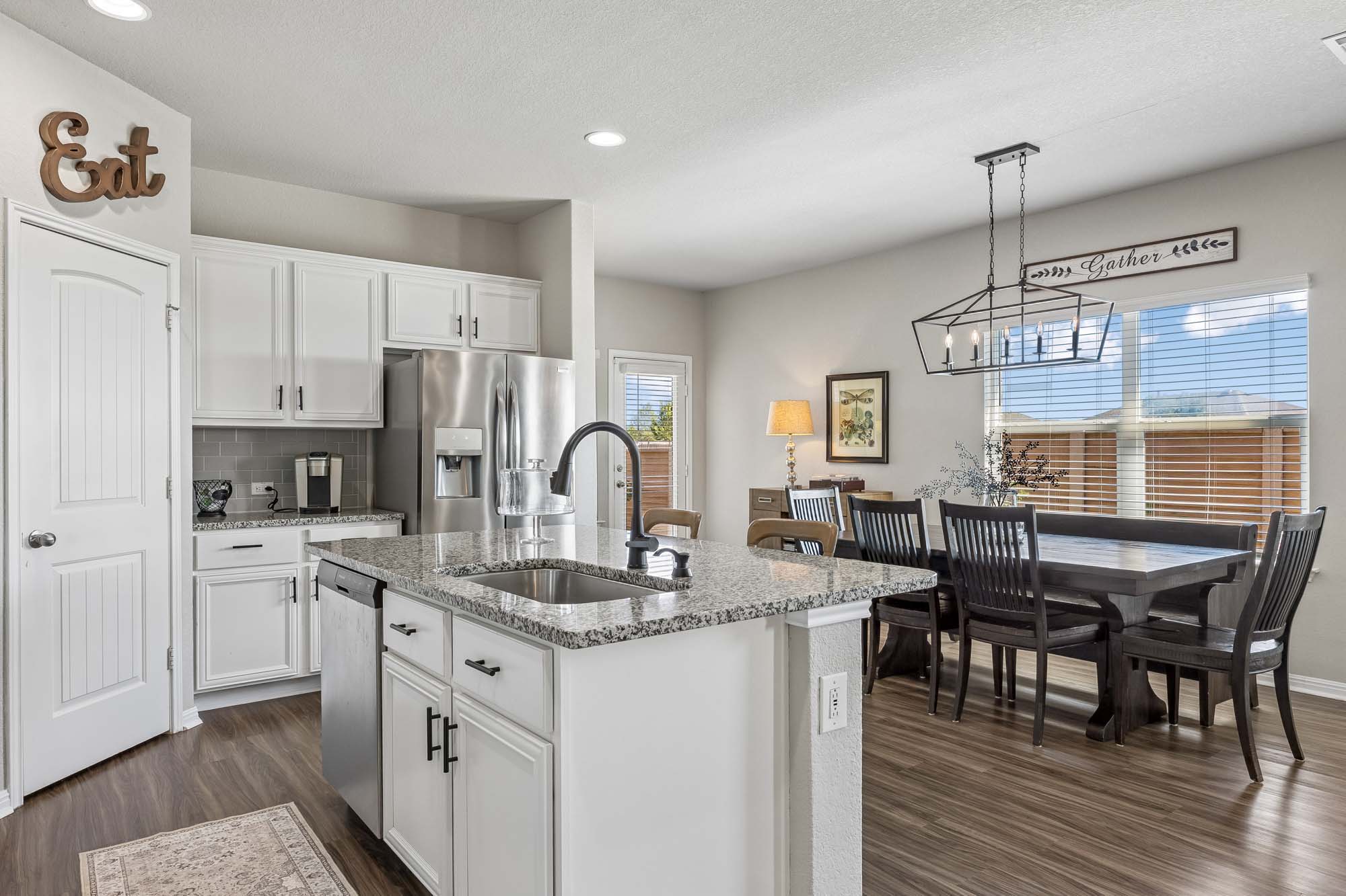 124 Moravia Road Georgetown, TX 78626 - Photo 4 of 38 An open kitchen and dining area showcase durable wood-look flooring and granite countertops.
